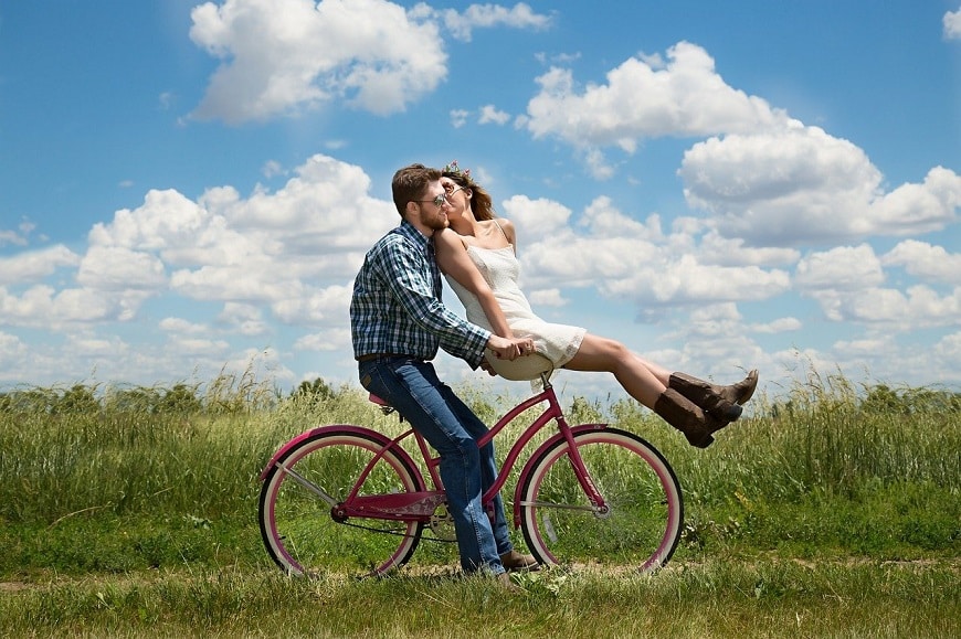 זוג מאוהב שהכיר באתר הכרויות רוכב יחד על אופניים