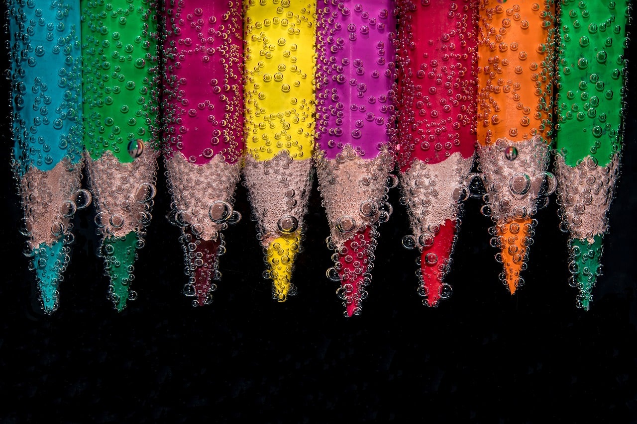 עפרונות צבעוניים טבולים במים